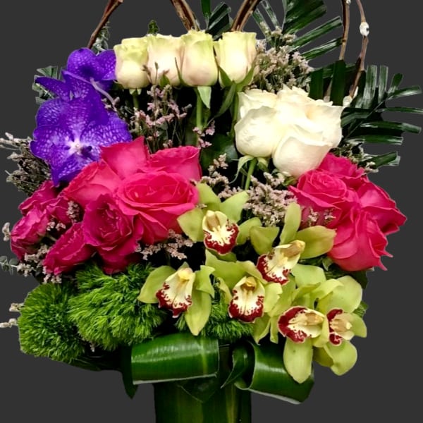 Colorful floral arrangement in a glass vase with roses and orchids