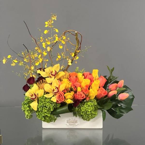 Bright mixed floral arrangement in a white rectangular box