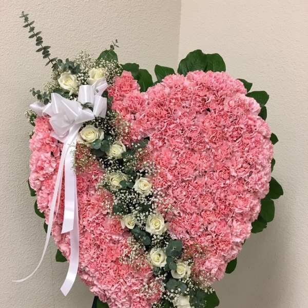 Heart-shaped pink floral standing spray with white roses and ribbon