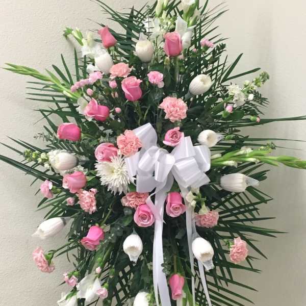 Pink and white floral standing spray with a white ribbon bow