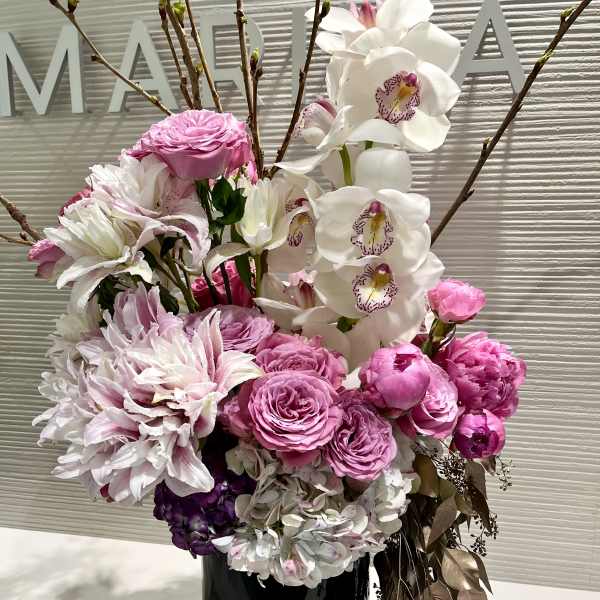 Pink and white floral arrangement in a black vase
