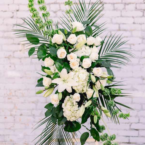 White floral standing spray with roses, lilies, and greenery
