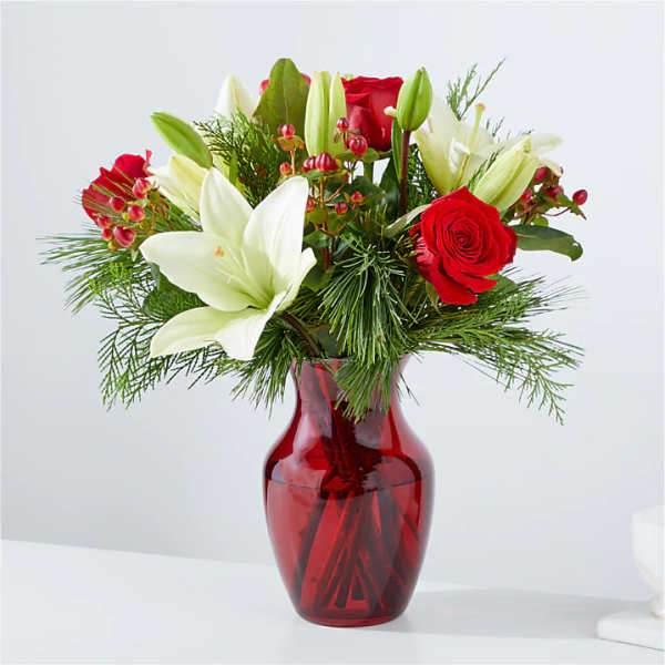 Red roses and white lilies in a red glass vase