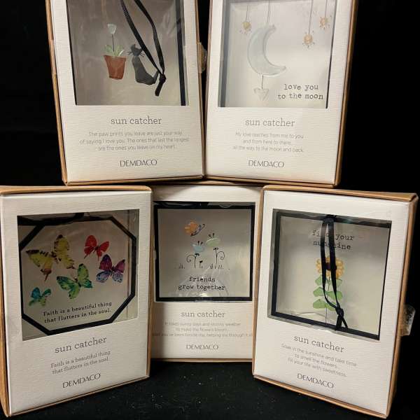 Boxes of decorative sun catchers with butterflies, moon, and flower designs