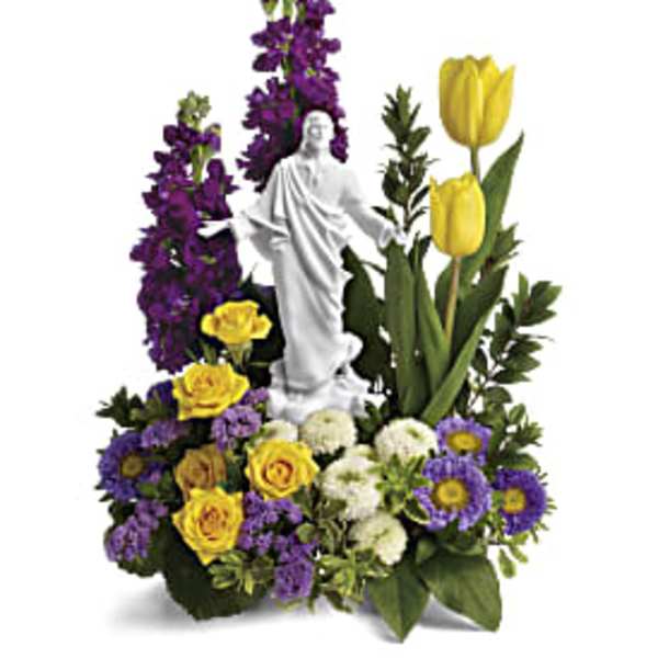 Floral arrangement with a white statue centerpiece, yellow tulips, and purple flowers