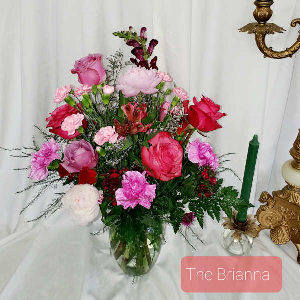 Pink and red mixed flower arrangement in a glass vase