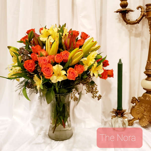Bouquet of orange roses and yellow lilies in a glass vase