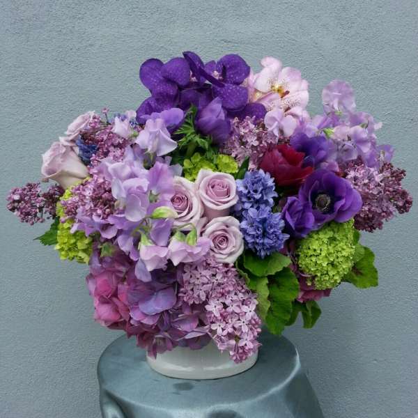 Purple and pink floral arrangement in a white vase