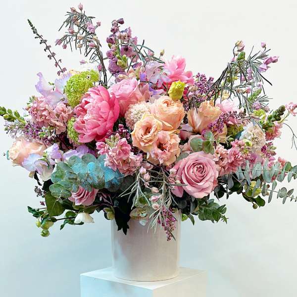 Large pastel bouquet in a white cylindrical vase