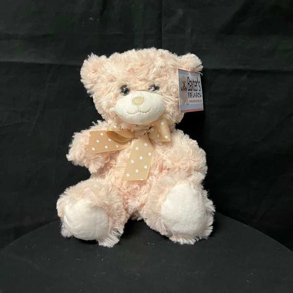 Plush teddy bear with a polka-dot ribbon bow