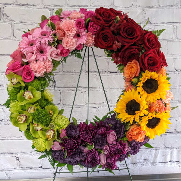 Colorful floral wreath on a metal stand with roses and sunflowers