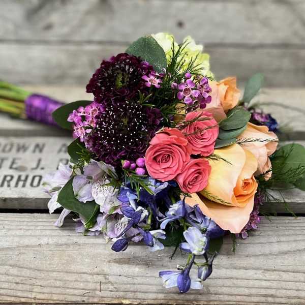 Mixed bouquet with pink and peach roses and purple flowers