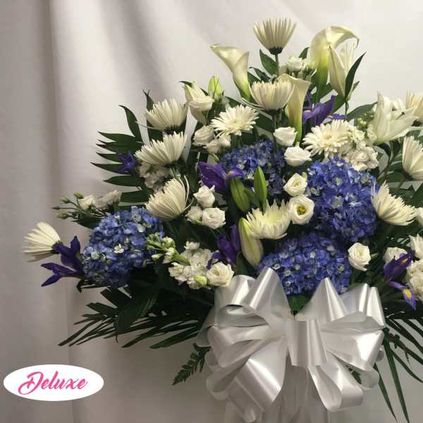 White and blue floral arrangement with a large silver bow