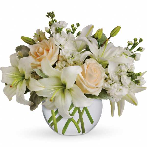 White lilies and cream roses arranged in a round glass vase