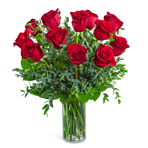 Red roses arranged in a clear glass vase with greenery