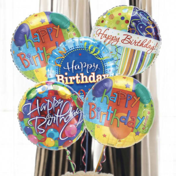 Birthday balloons above a teddy bear