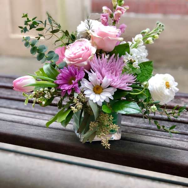 Pink and white mixed flower arrangement in a clear glass vase