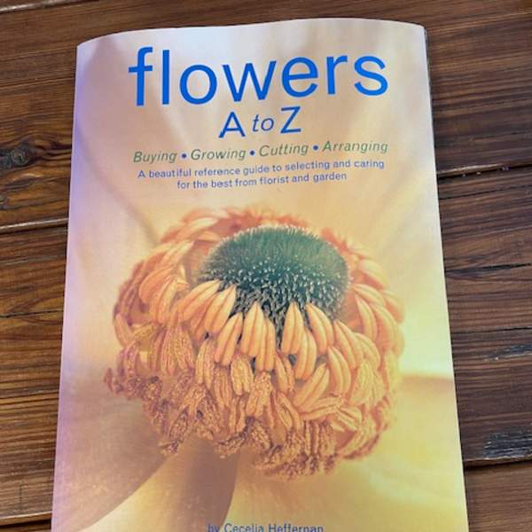 A book titled "flowers A to Z" on a wooden surface