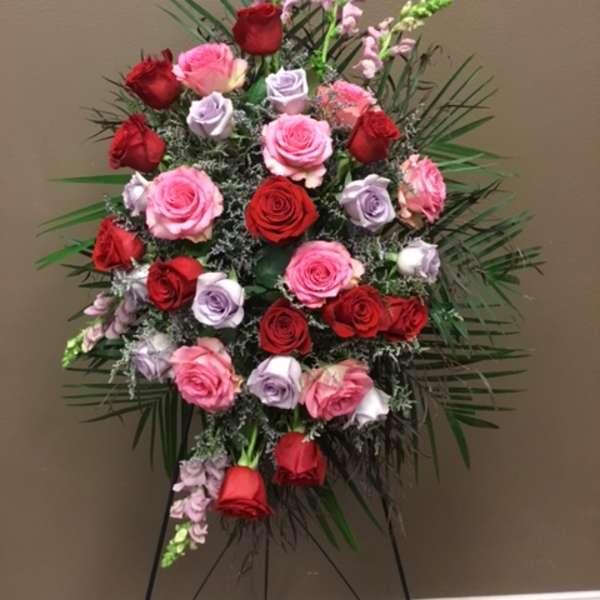 Standing floral spray of red, pink, and lavender roses