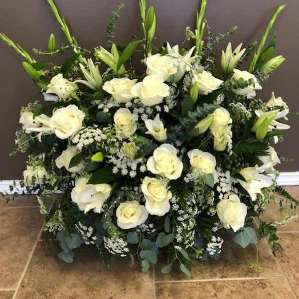 Large white floral arrangement with roses and lilies