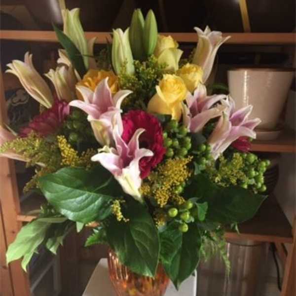 Mixed bouquet of lilies and roses in a glass vase