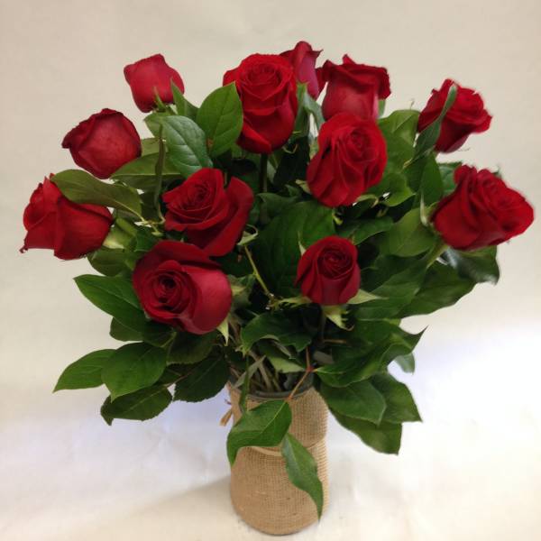 Bouquet of red roses in a burlap-wrapped vase