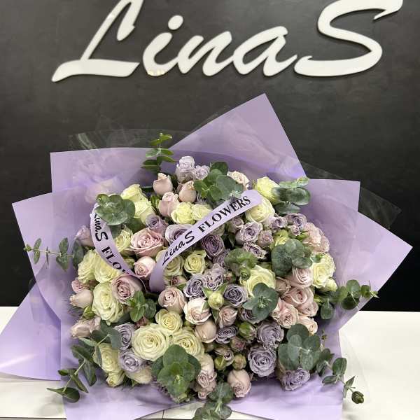 Large bouquet of pastel roses wrapped in lavender paper