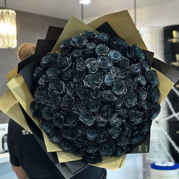 Large bouquet of dark blue-black roses wrapped in black and gold paper