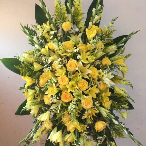 Large yellow floral standing spray with roses and lilies