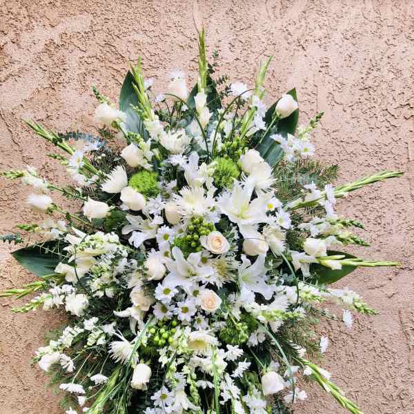 Large white floral spray with lilies, roses, and daisies