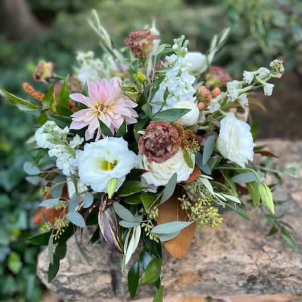 Loose bouquet of pale pink and white flowers with mixed greenery