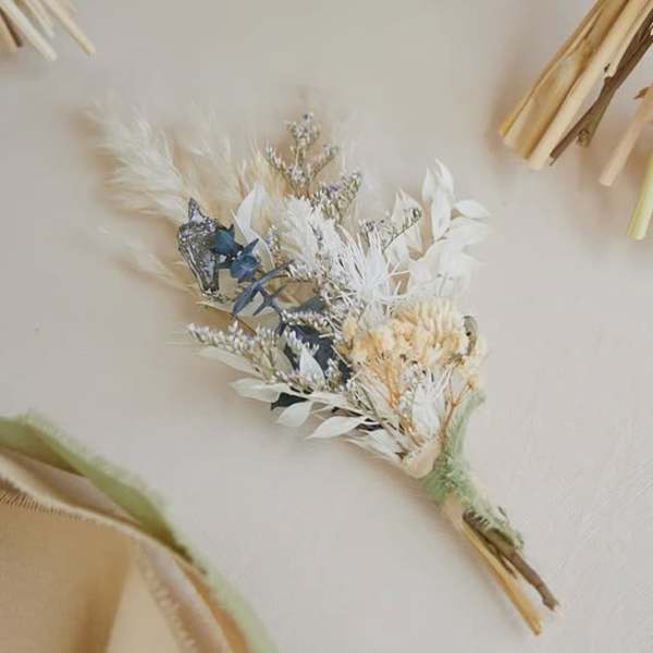 Small dried bouquet with white and blue accents on a neutral background