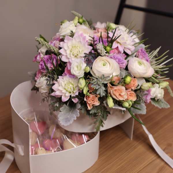 Bouquet of pastel pink and white flowers in a white box with a clear gift bag