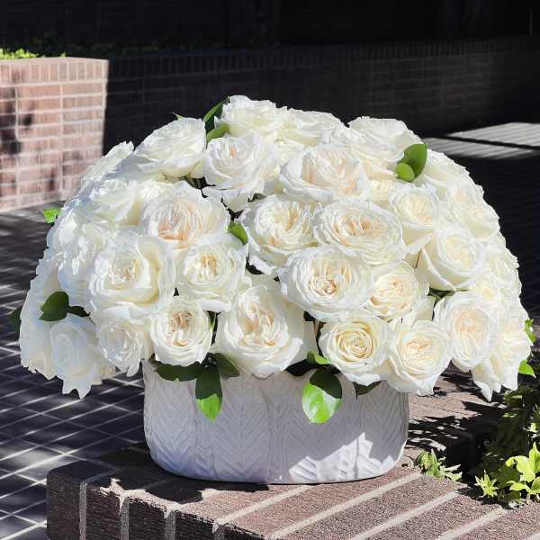 White rose arrangement in a textured white vase