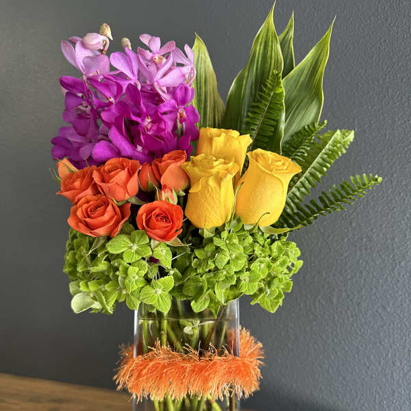 Colorful bouquet of orchids and roses in a glass vase with orange trim
