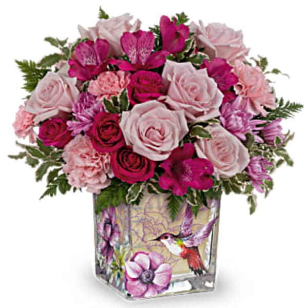 Pink and magenta roses arranged in a decorated glass vase