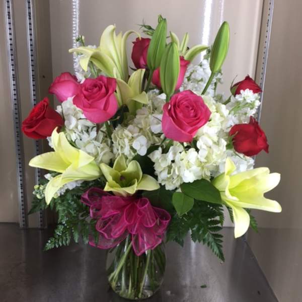 Bouquet of pink roses and white lilies in a glass vase