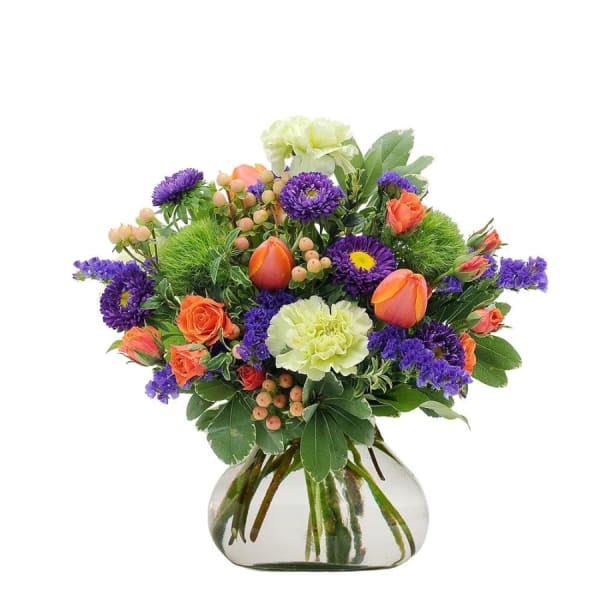 Bouquet of orange and purple flowers in a clear glass vase
