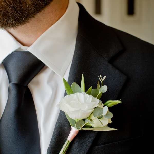 White boutonniere pinned to a black suit jacket