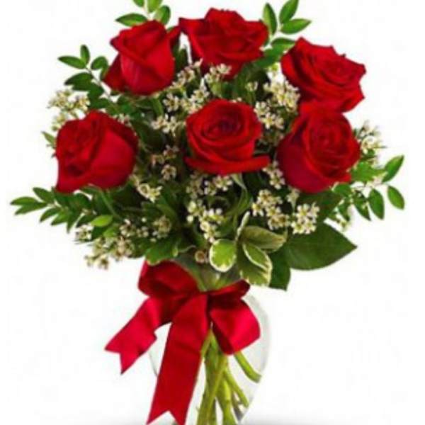 Bouquet of red roses with greenery and a red ribbon in a glass vase