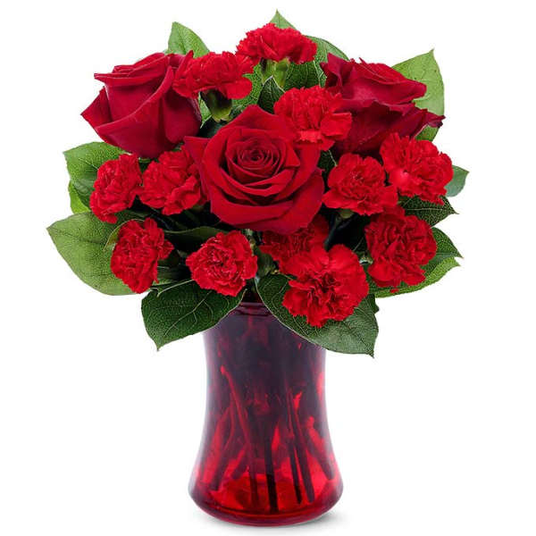 Red roses and carnations arranged in a red glass vase