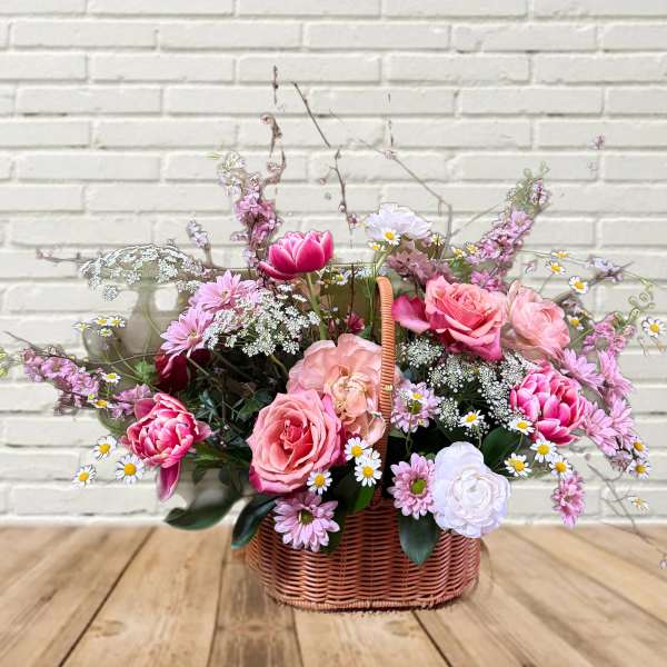 Pink and white mixed flower arrangement in a wicker basket