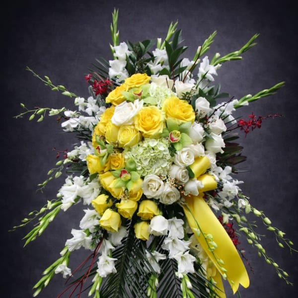 Standing floral spray with yellow and white roses and white orchids