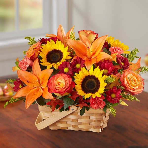 Basket arrangement with sunflowers, orange lilies, and roses