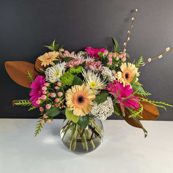 Mixed bouquet of gerbera daisies and chrysanthemums in a glass vase