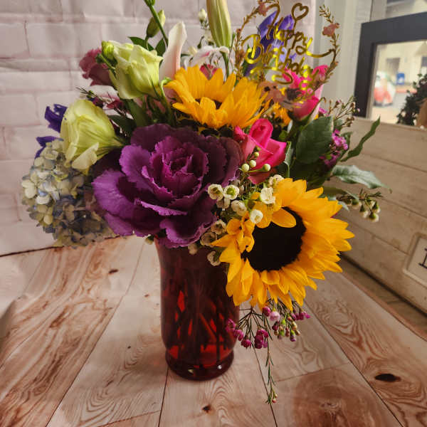 Colorful bouquet in a red vase with a birthday topper