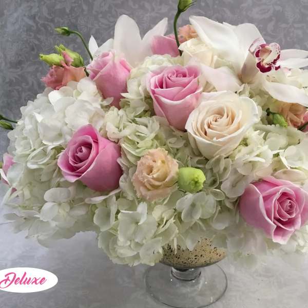 Pink and white rose arrangement in a glass vase