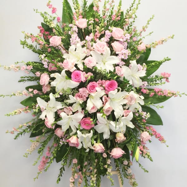 Large pink and white floral standing spray on an easel