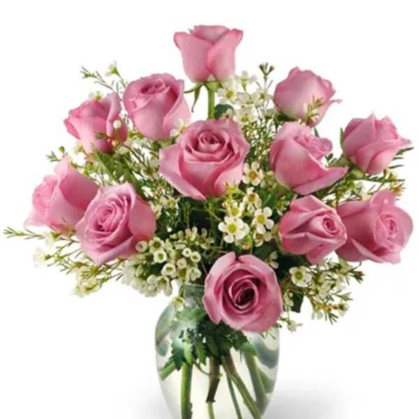 Pink roses arranged in a clear glass vase with small white filler flowers