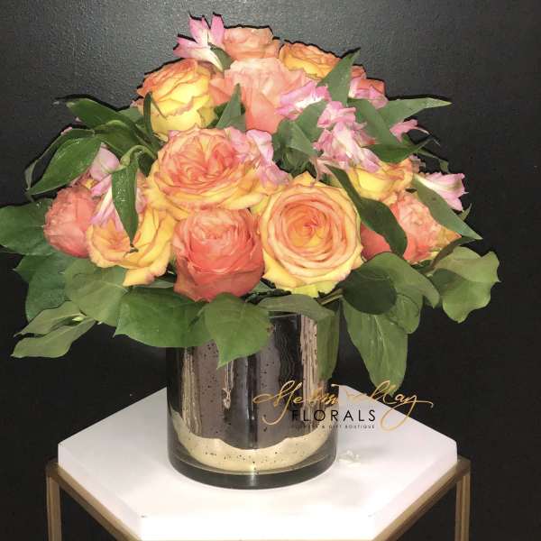 Bouquet of peach and yellow roses in a glass vase